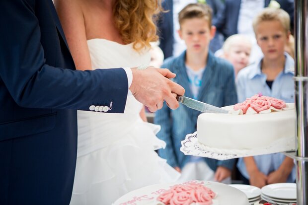 Bruidstaart met roze rozen in het midden